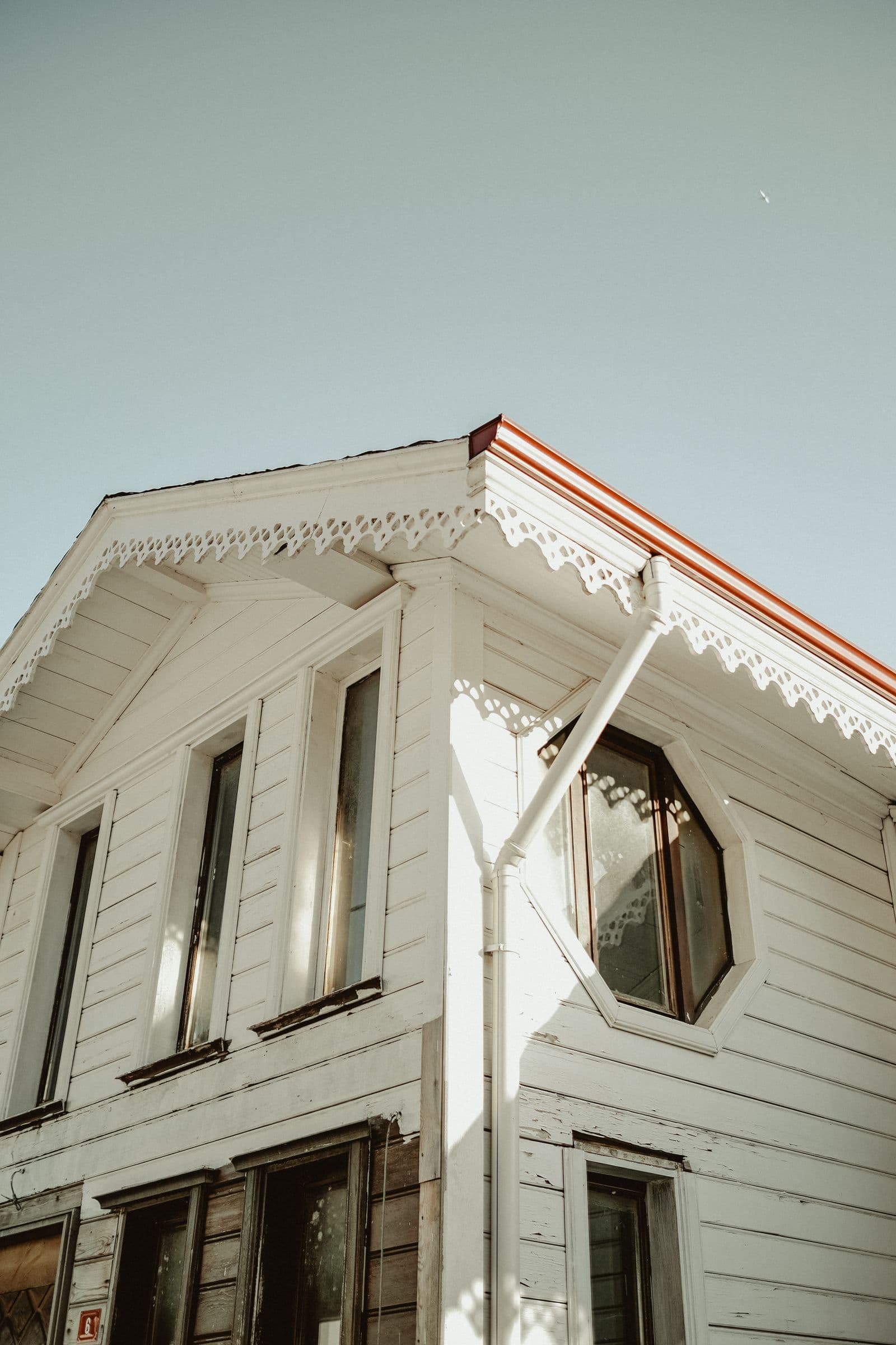 Clean white uPVC fascia boards and soffit panels on a house roofline against blue sky