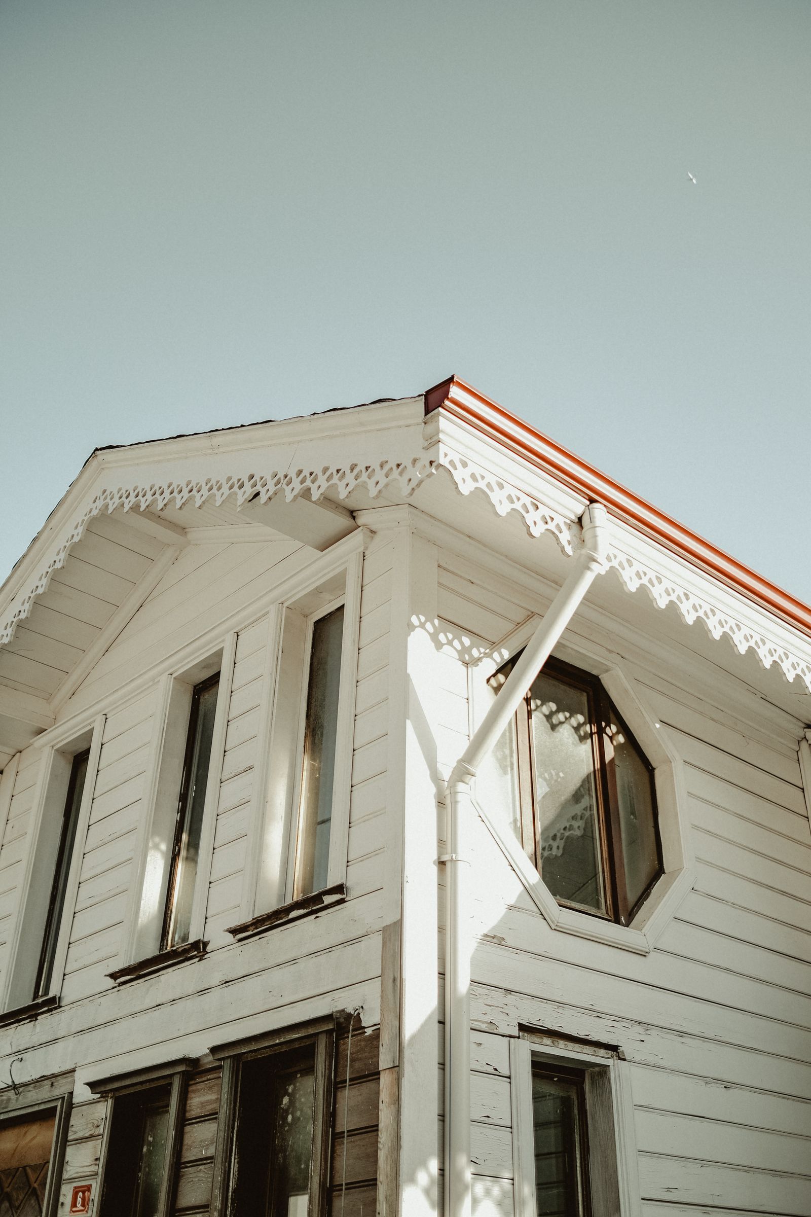 Clean white uPVC fascia boards and soffit panels on a house roofline against blue sky